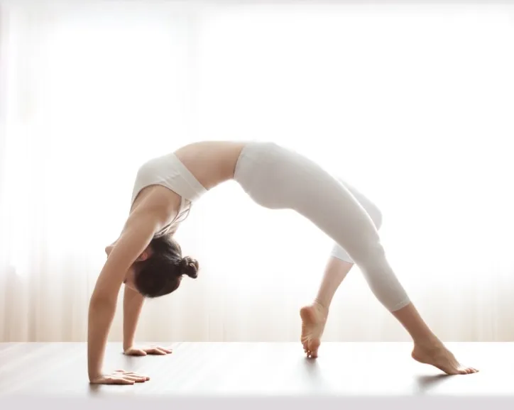 woman performing a bridge pose in a pilates class